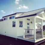 White Farmhouse Premier P577 with grey painted cabs, clerestory, and an optional island by Platinum Cottages. This custom built house was for an RRC Athens customer