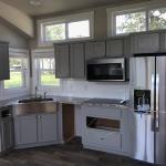 White Farmhouse Premier P577 with grey painted cabs, clerestory, and an optional island by Platinum Cottages. This custom built house was for an RRC Athens customer